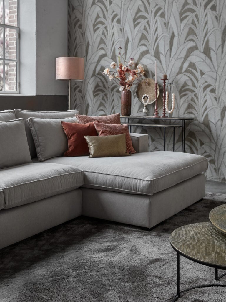 Detail of the Annabelle Square corner sofa in a light beige fabric with round coffee tables and a large rug.