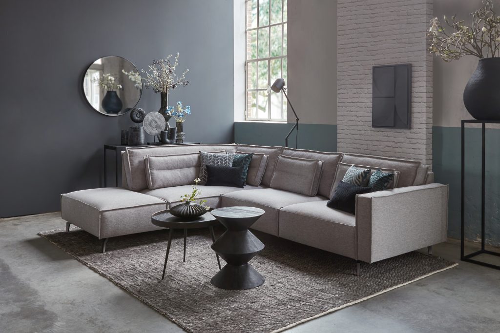 Graues Ecksofa mit schwarzen Akzenten und Accessoires
