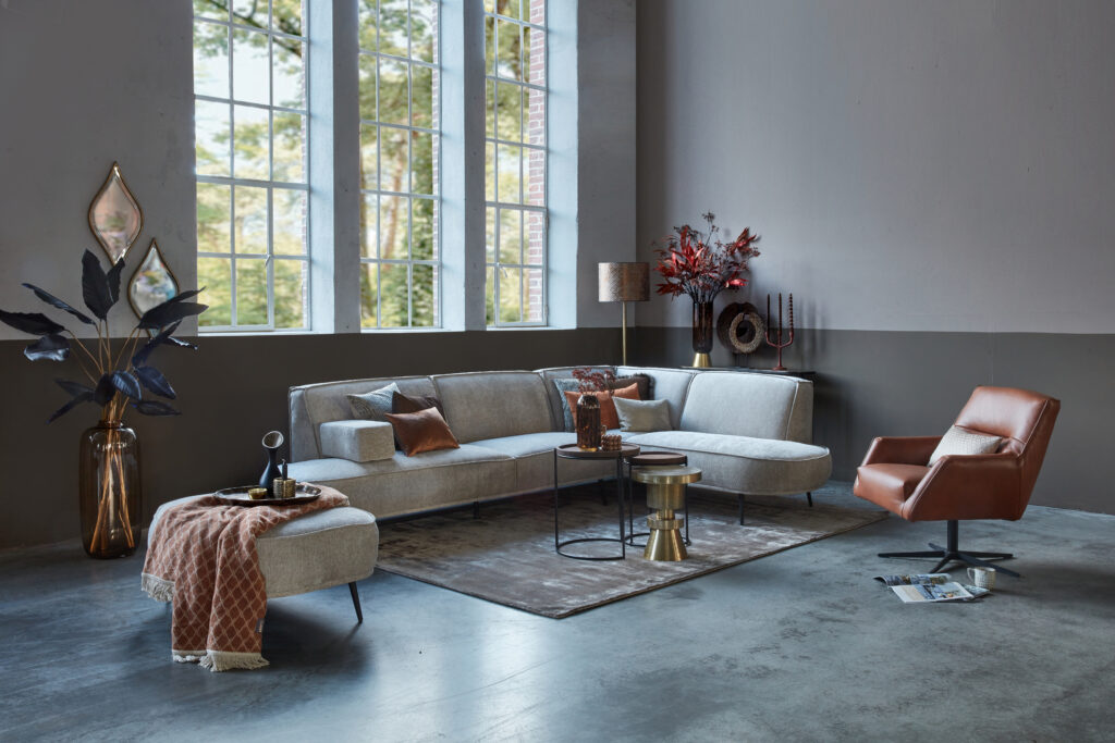 Beige corner sofa Arielle with round shapes and cognac leather armchair Tommy Smal.