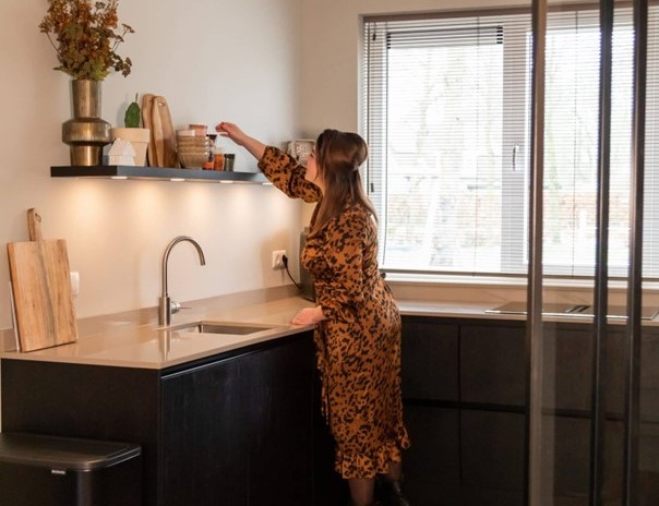 binnenkijken in een sfeervolle woning, beige bank met rond vloerkleed.