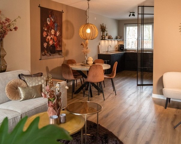 binnenkijken in een sfeervolle woning, beige bank met rond vloerkleed.