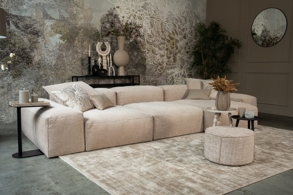 Helles Ecksofa mit hellen und beigen Accessoires.