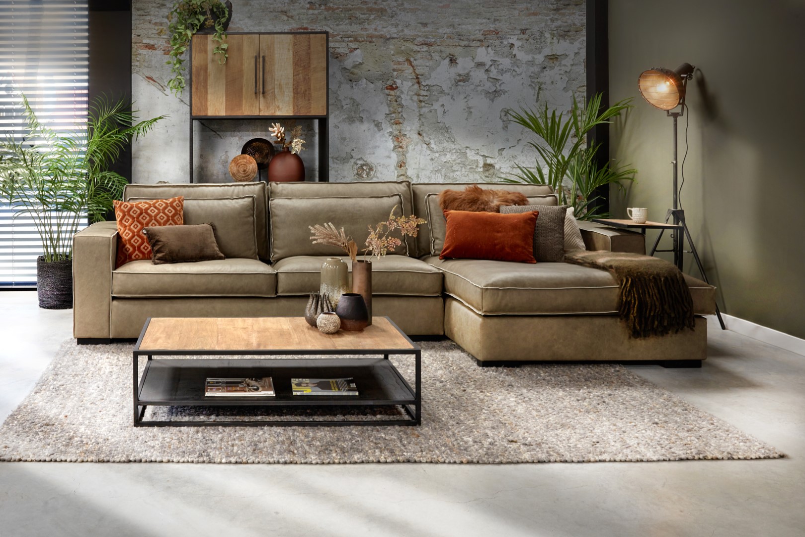 Grünes Sofa von Room108 in coolem Interieur mit orangefarbenen Zierkissen