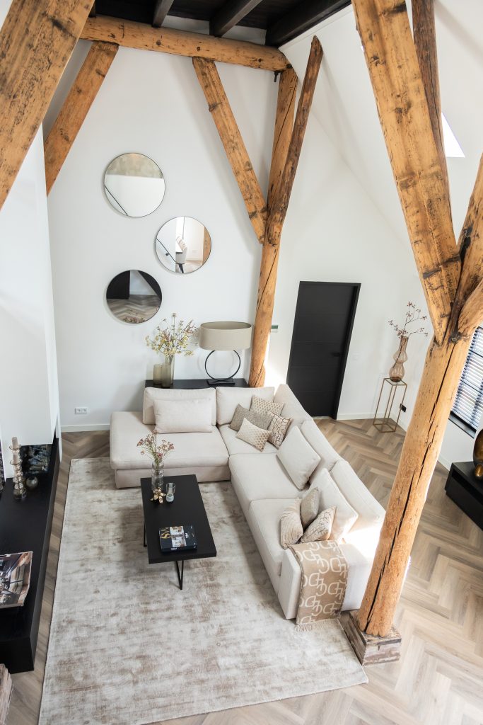 Photo of living room with wooden beams and light sofa.