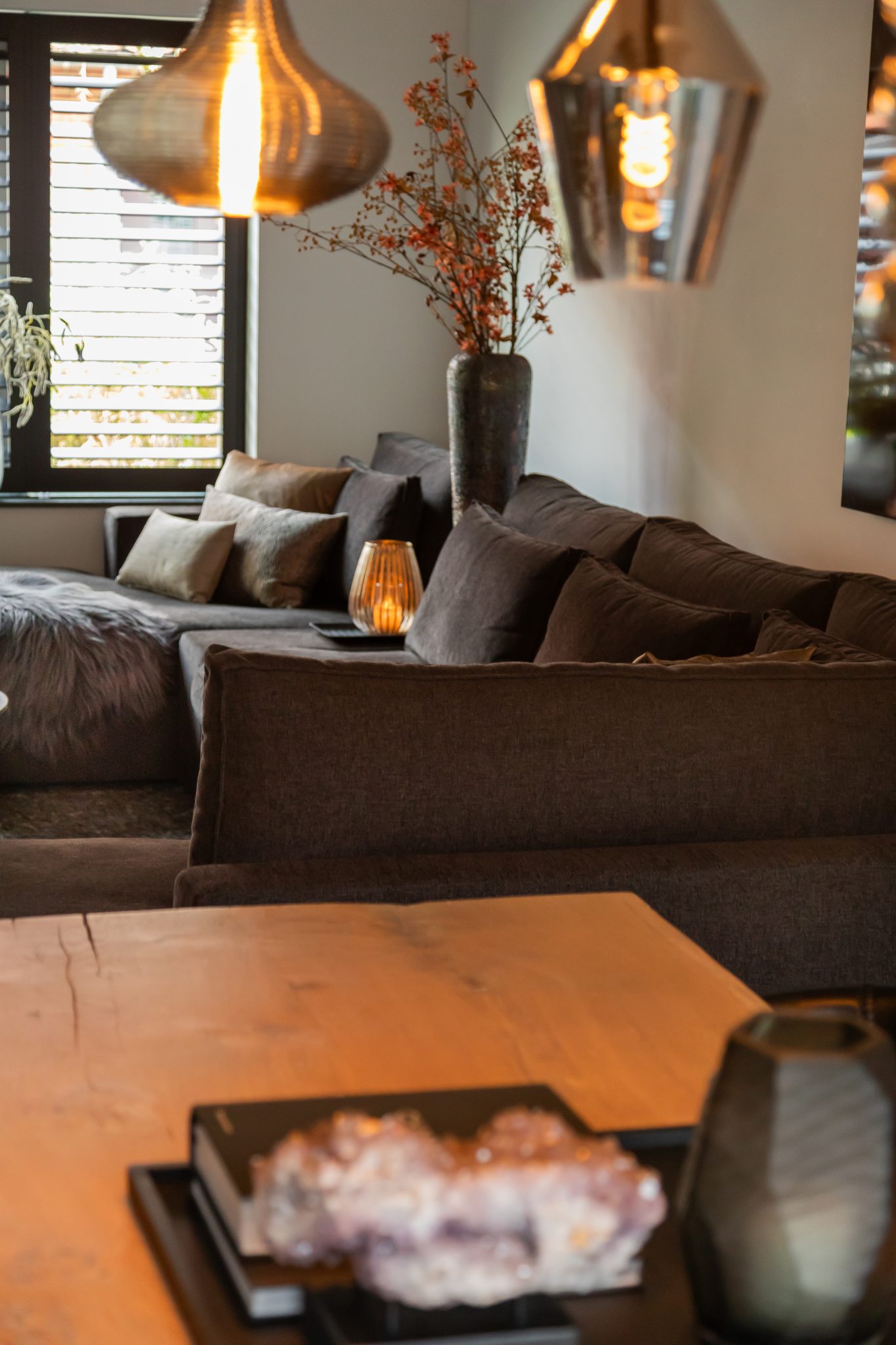 Grijze bank en grote bloemenvaas in een stijlvol interieur.