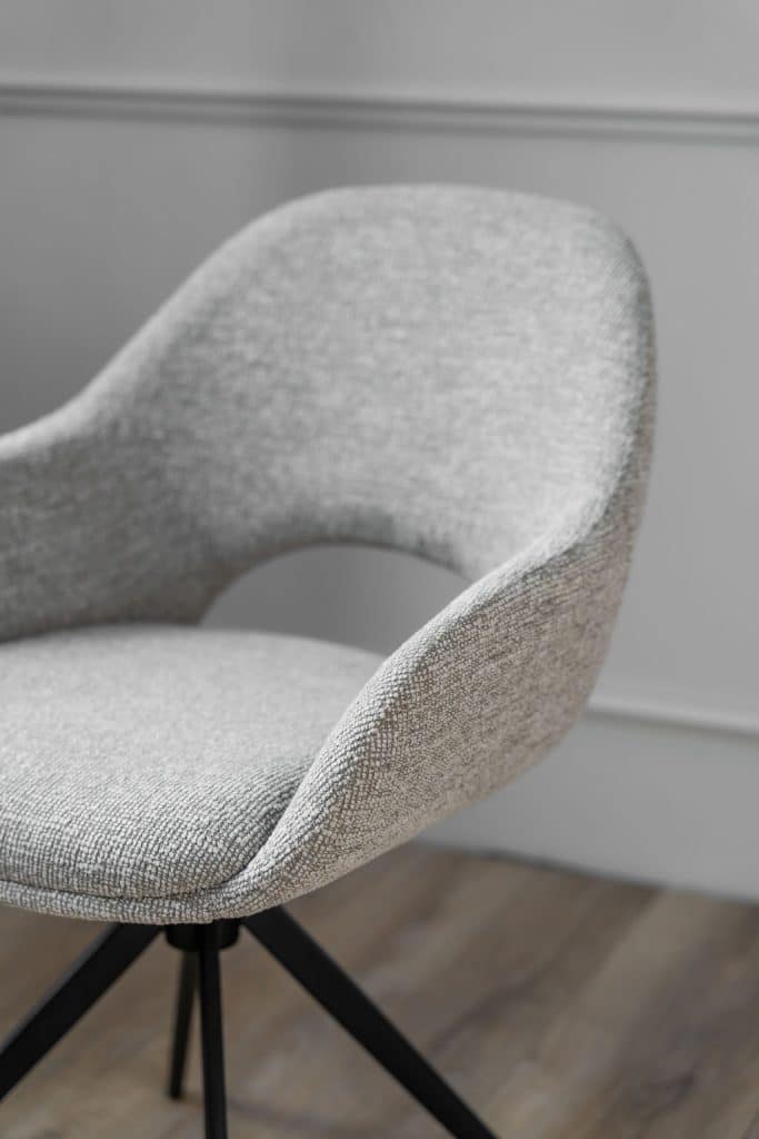 De eetkamerstoel is uitgevoerd in een lichte stof en heeft een draaifunctie