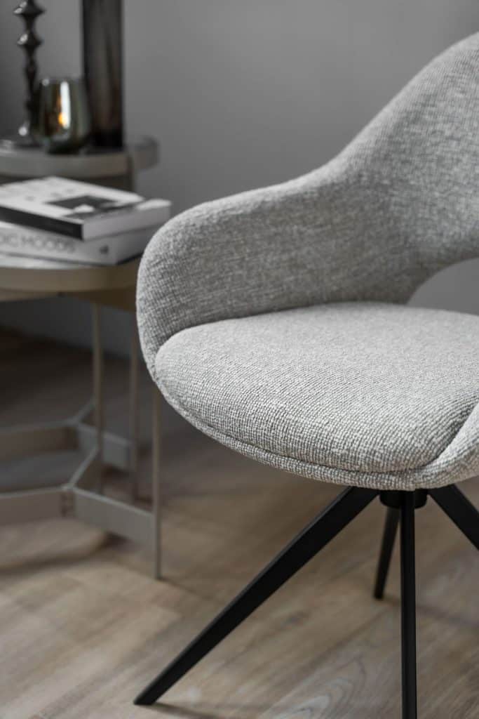 De eetkamerstoel is uitgevoerd in een lichte stof en heeft een draaifunctie