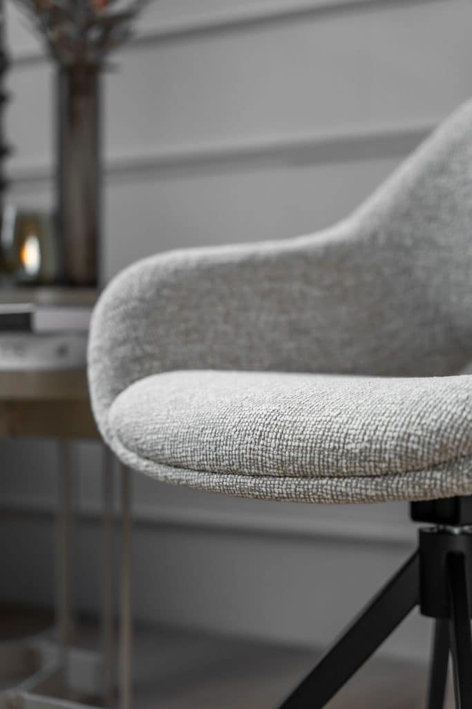 De eetkamerstoel is uitgevoerd in een lichte stof en heeft een draaifunctie