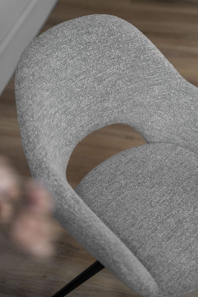 De eetkamerstoel is uitgevoerd in een lichte stof en heeft een draaifunctie