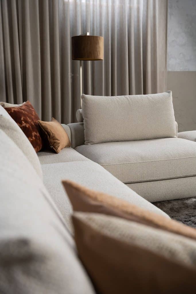 Divano beige con vari elementi e un accattivante stile interno rosso/rosa.