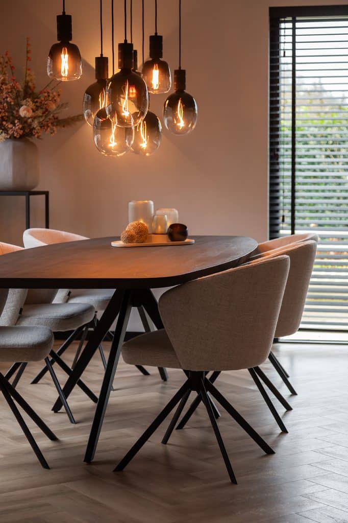 un aperçu de la maison de Linda, depuis le compte Instagram @stulpjeopdeveluwe. Avec table à manger ovale danoise et chaises de salle à manger beiges. Avec lampe suspendue en verre d'ambiance.