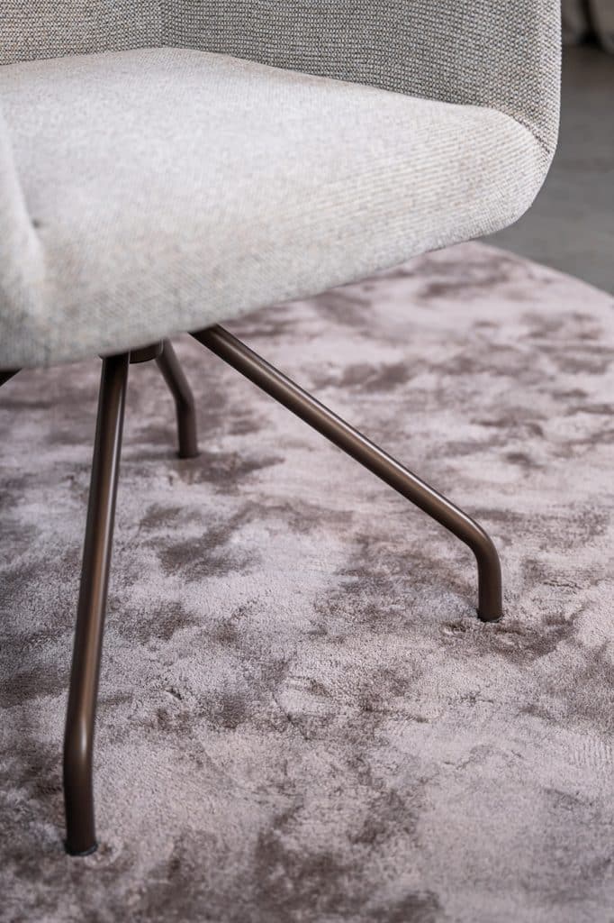 Detail van lichte natural eetkamerstoel met armleuning.