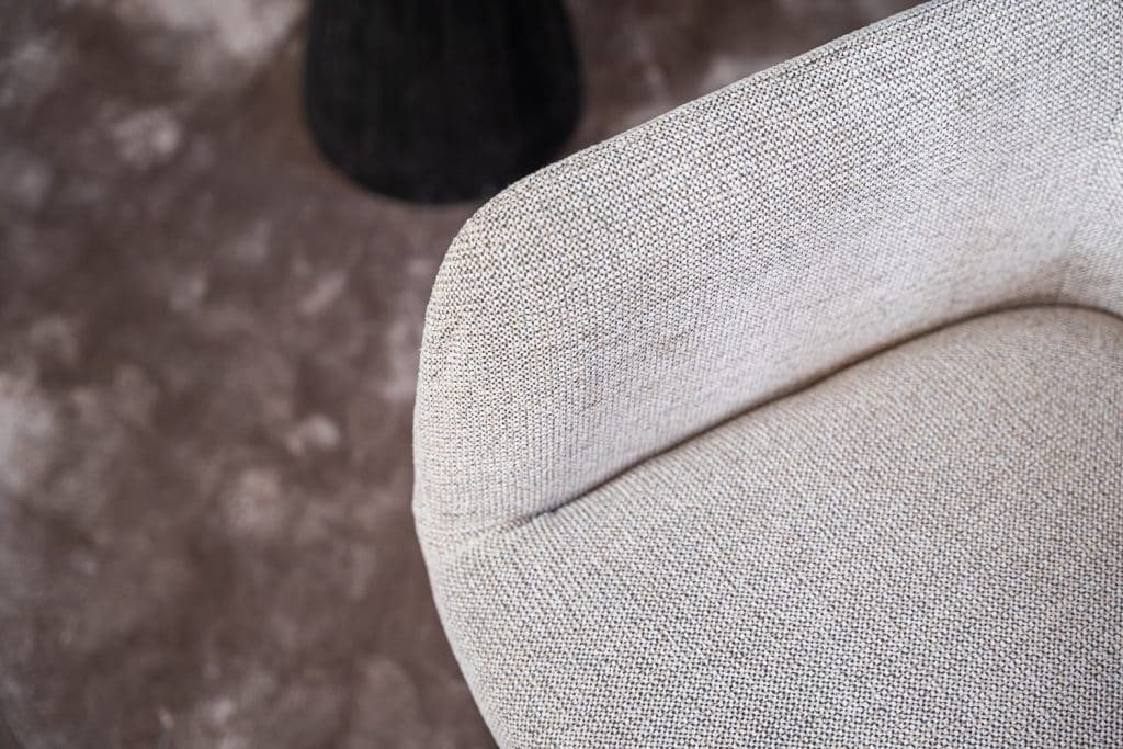 Detail van lichte natural eetkamerstoel met armleuning.