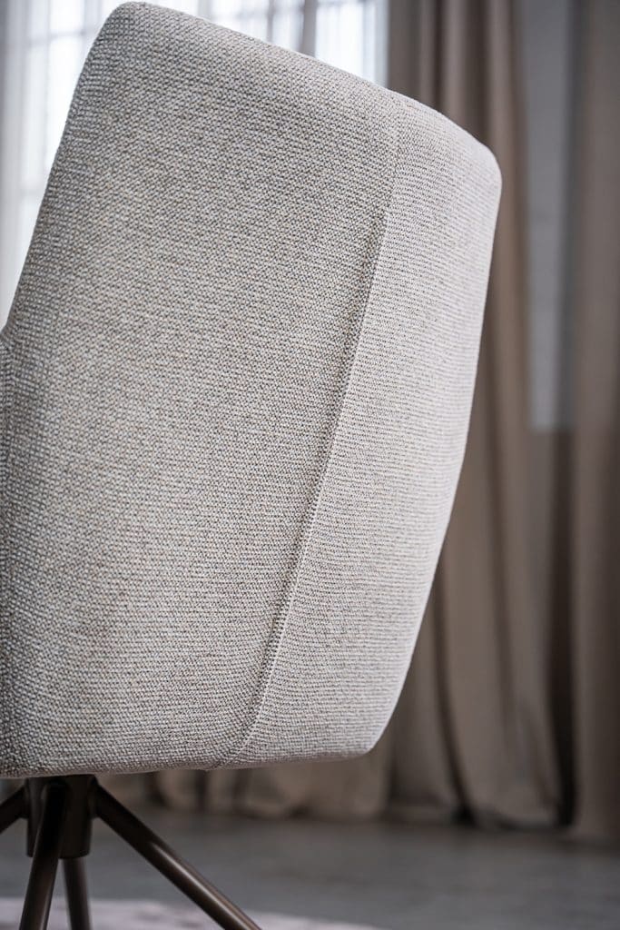 Detail van lichte natural eetkamerstoel met armleuning.