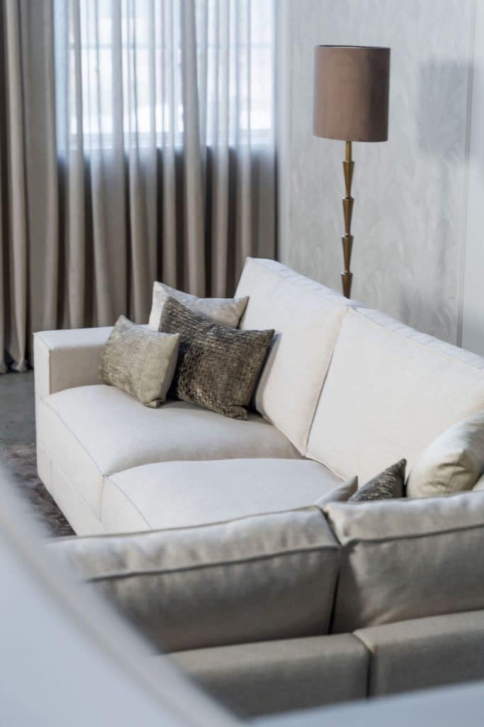 Light beige corner sofa with brown home accessories.