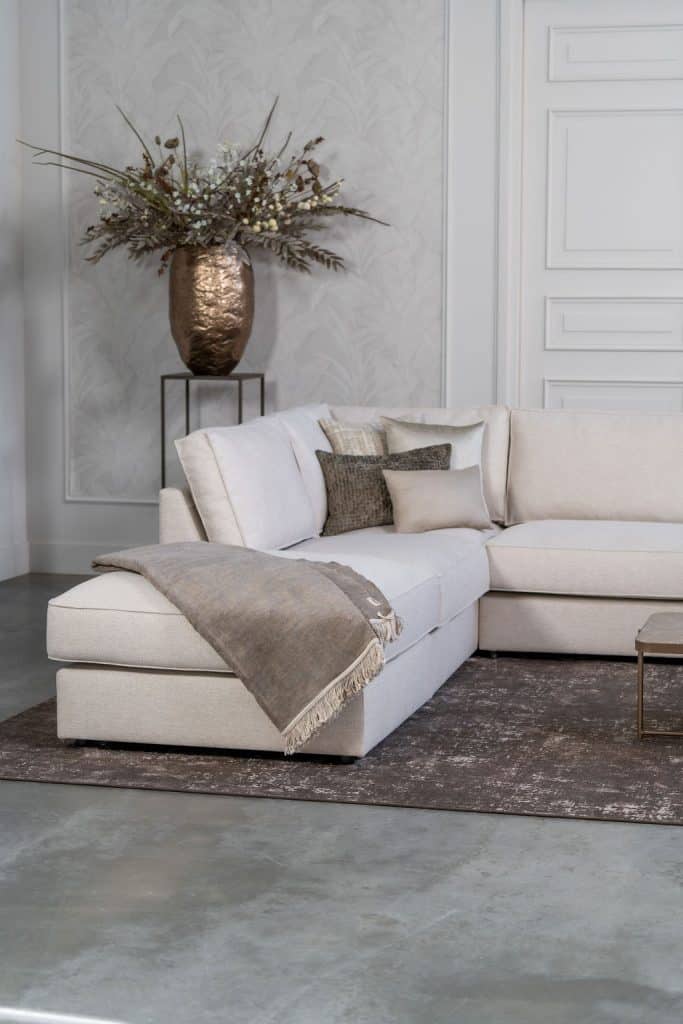Light beige corner sofa with brown home accessories.