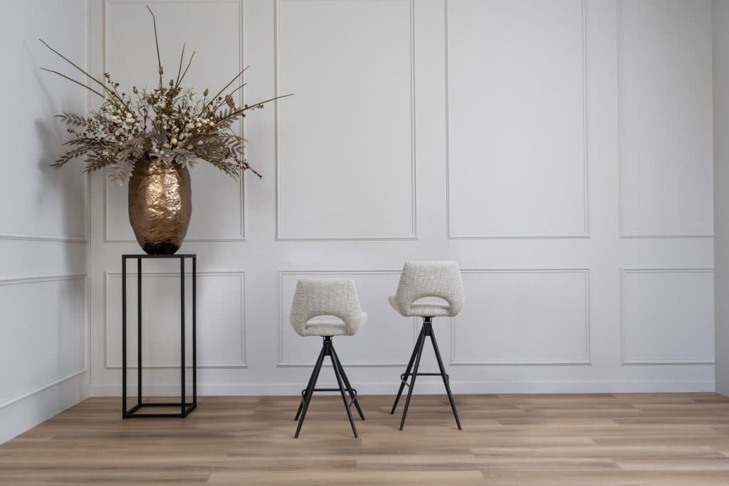 Beige bar stool in 2 different heights with a black leg.