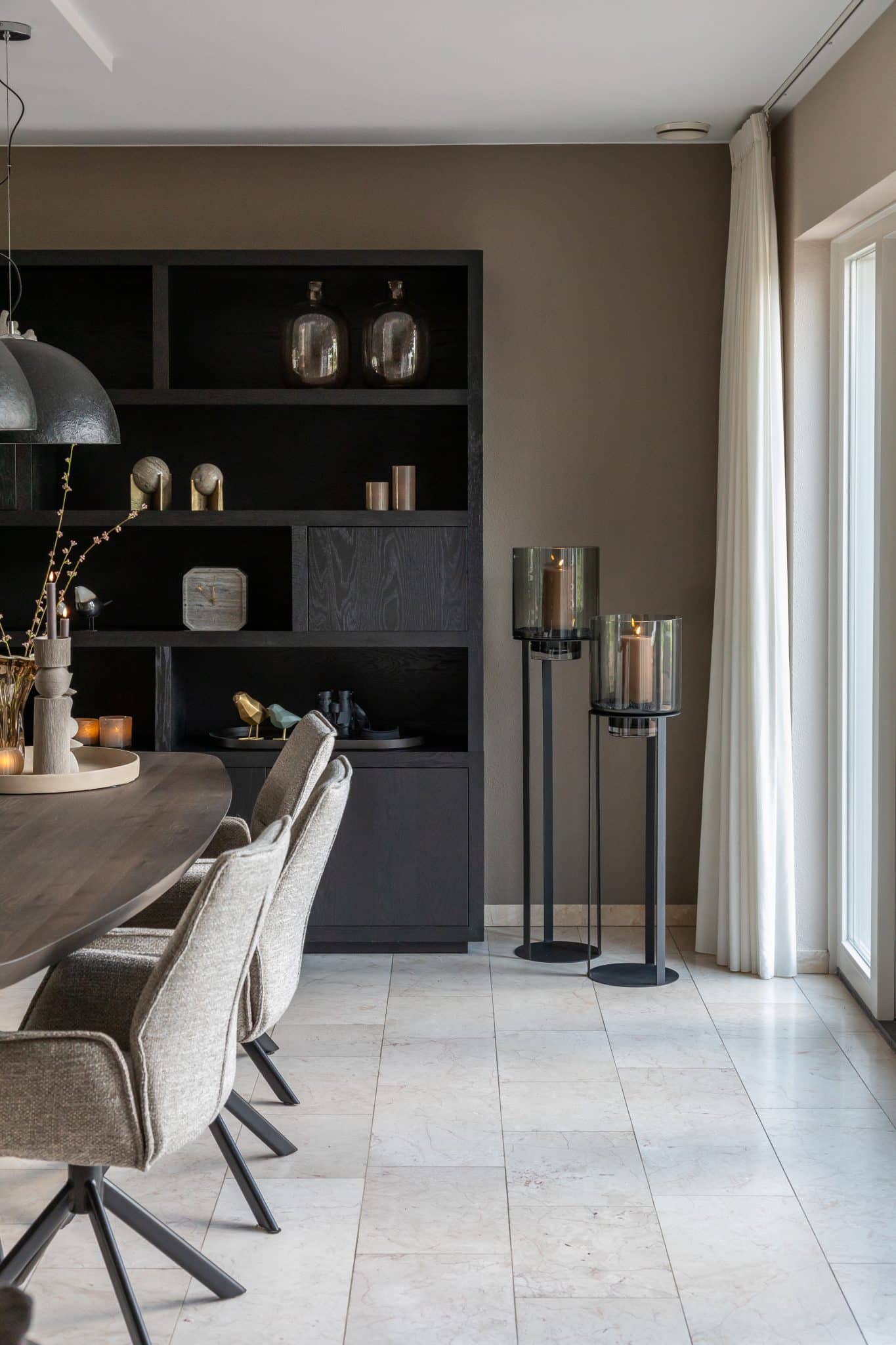 Binnenkijken bij klanten thuis met een grote beige lounge bank en chique eettafel met bijpassende eetkamerstoelen.