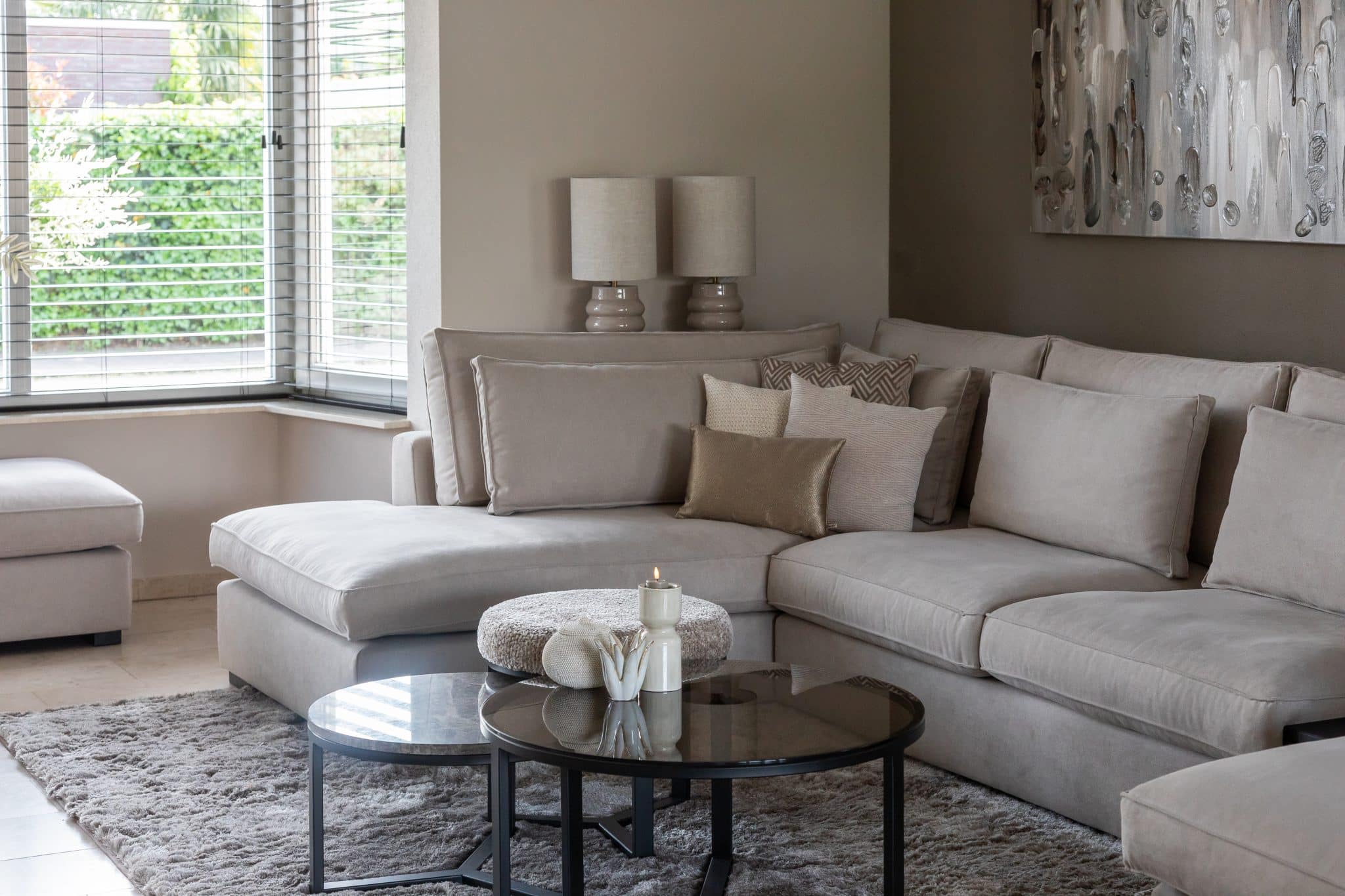 Binnenkijken bij klanten thuis met een grote beige lounge bank en chique eettafel met bijpassende eetkamerstoelen.