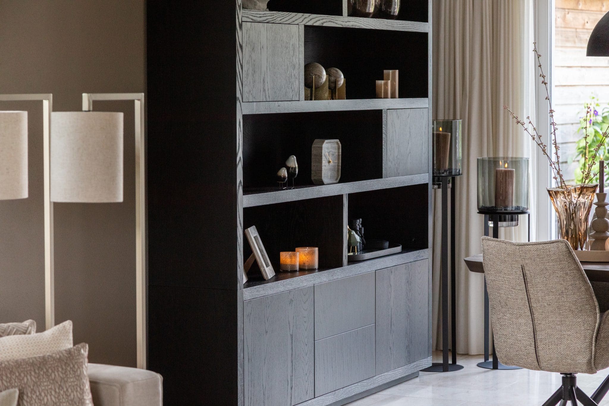 Binnenkijken bij klanten thuis met een grote beige lounge bank en chique eettafel met bijpassende eetkamerstoelen.