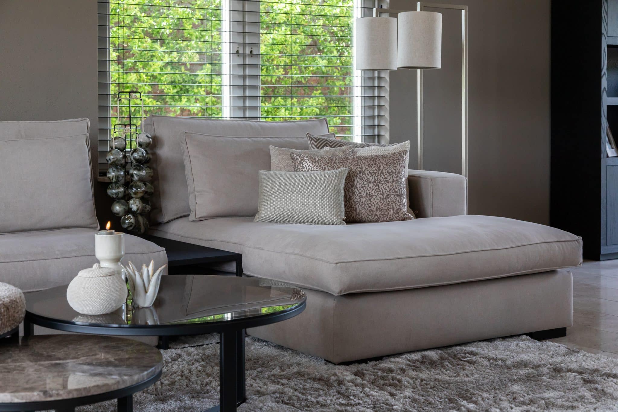 Binnenkijken bij klanten thuis met een grote beige lounge bank en chique eettafel met bijpassende eetkamerstoelen.