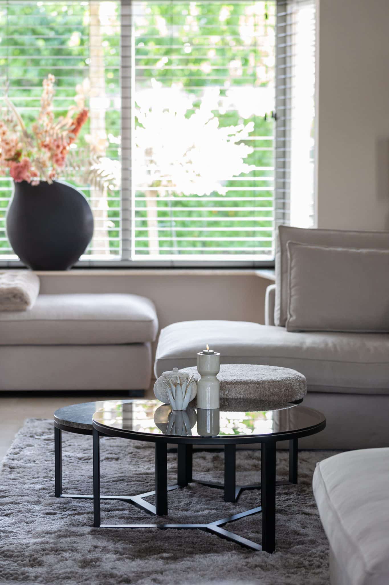 Binnenkijken bij klanten thuis met een grote beige lounge bank en chique eettafel met bijpassende eetkamerstoelen.